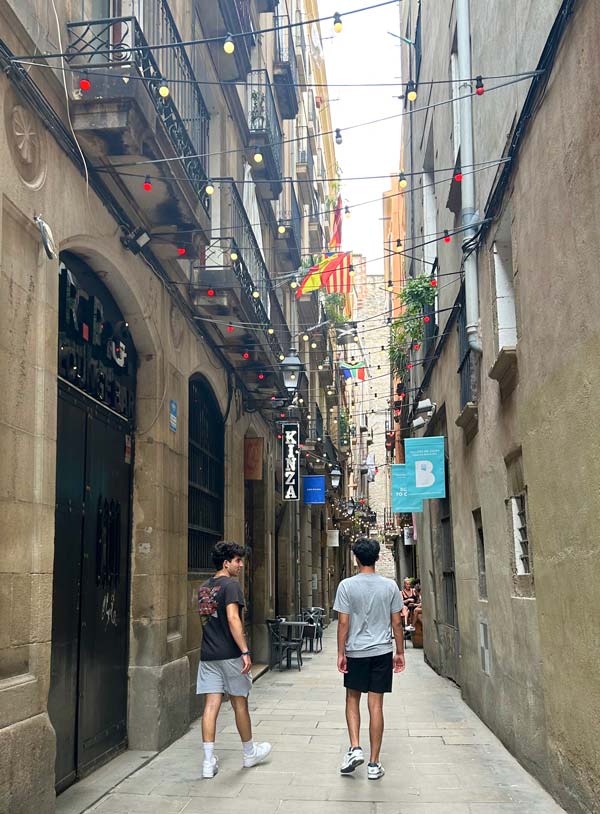 两个留学生走在一条狭窄的街道上