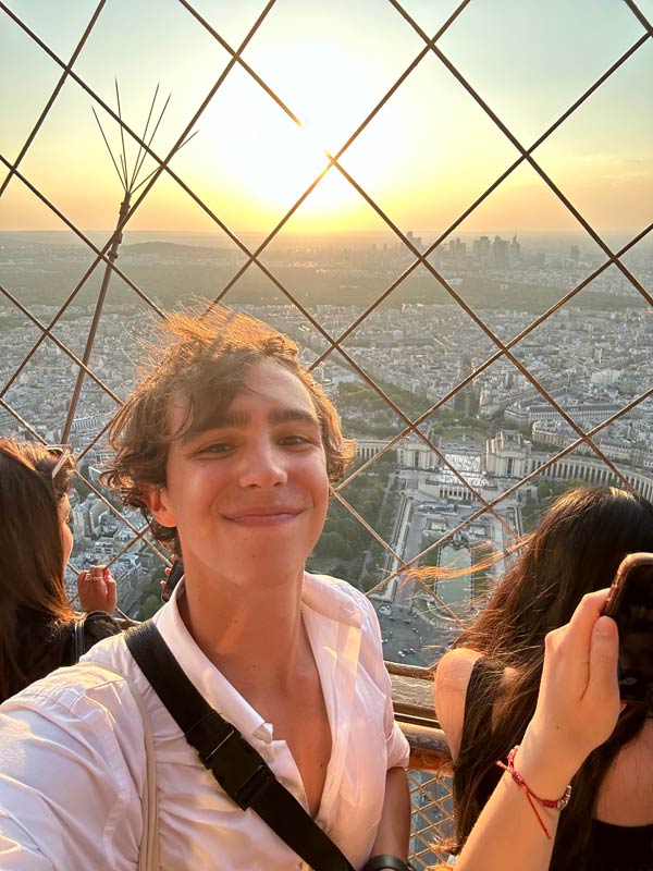 A study abroad student taking a selfie from a tall height with a city in the background