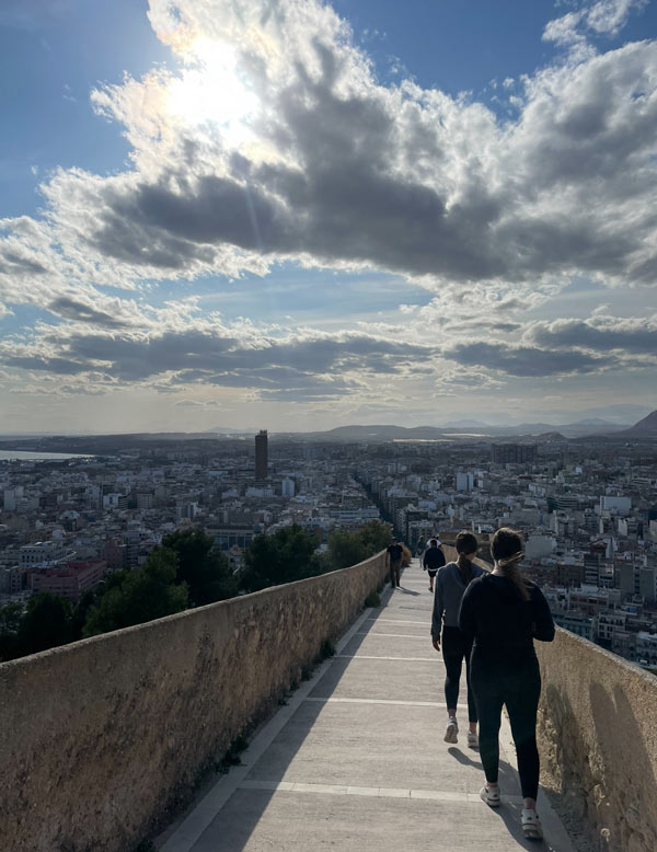 Study abroad students walking down a walkway with a city in the background