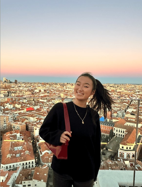 a study abroad student posing for a picture above a city