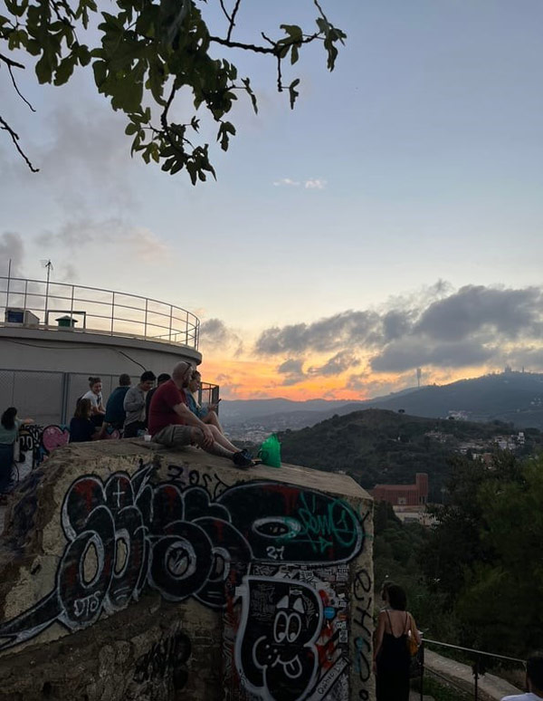 A group of study abroad students sitting on a rock with graffiti on it