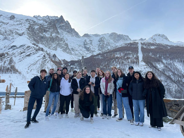 A group of study abroad students posing for a photo in the snow