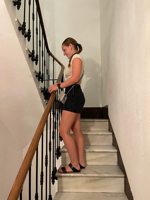 a study abroad student standing on a staircase looking down