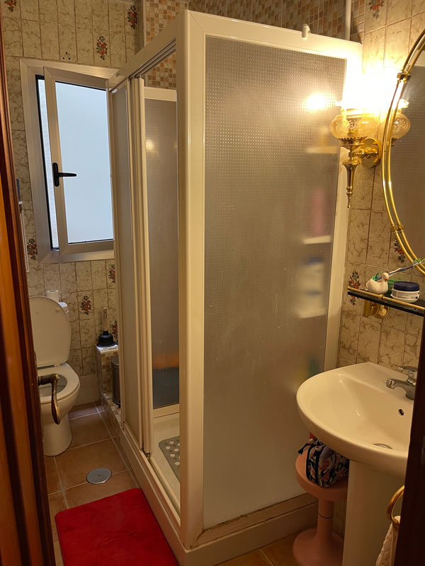 a small bathroom for study abroad students with a sink shower and toilet