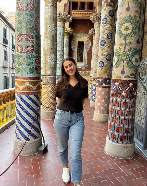 A study abroad student standing in front of a colorful column