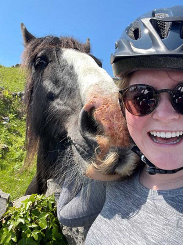 A study abroad student taking a selfie with a horse