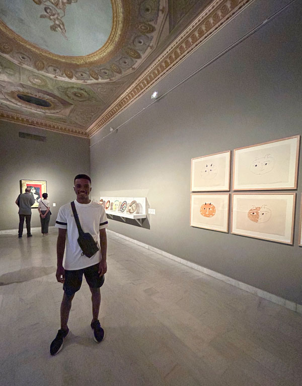 A study abroad student standing in a room with art on the wall
