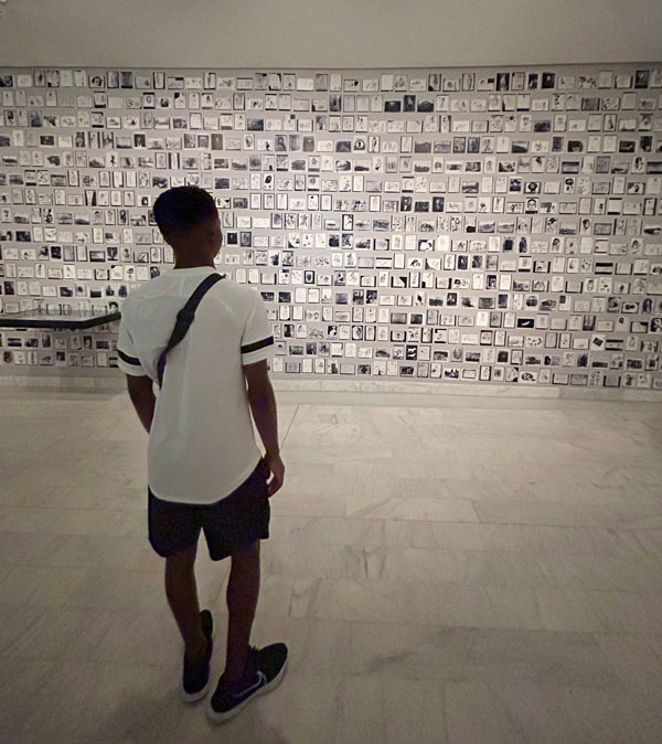 A study abroad student looking at a wall of pictures