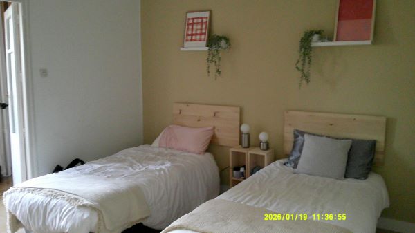 A study abroad student bedroom, featuring two small beds with pillows