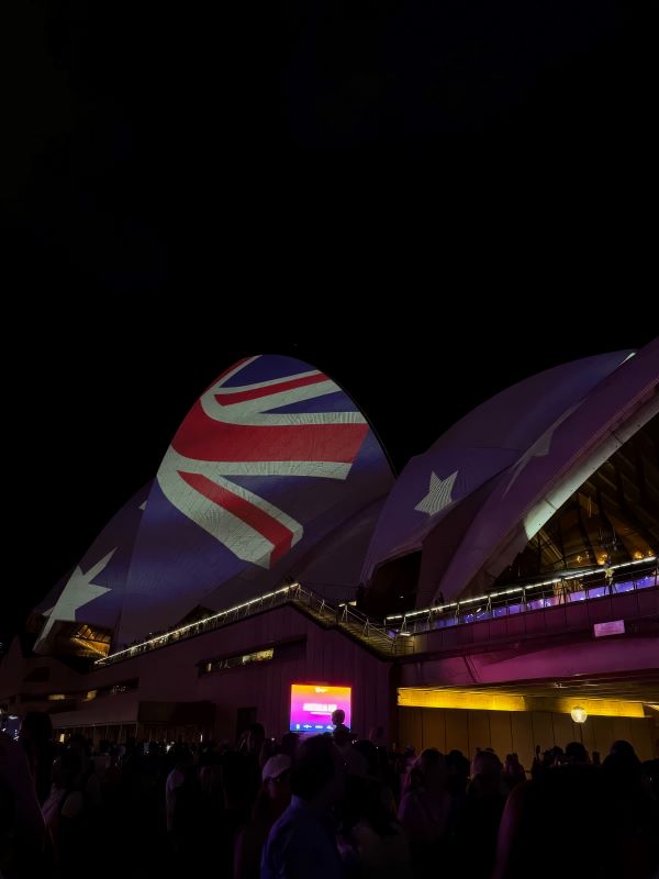 A large building with the Australian flag projected onto it at nighttime