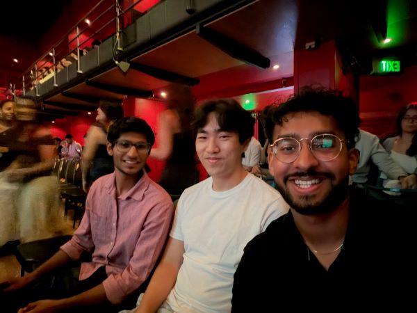 Three study abroad students seated in a performance venue and smiling at the camera