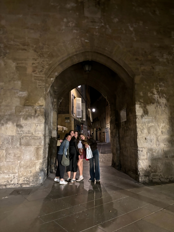 Four study abroad students posing for a photo at night on the streets of Aix-en-Province