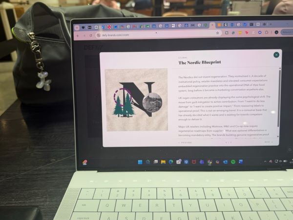 An open laptop sat on a table indoors with a screen featuring the words