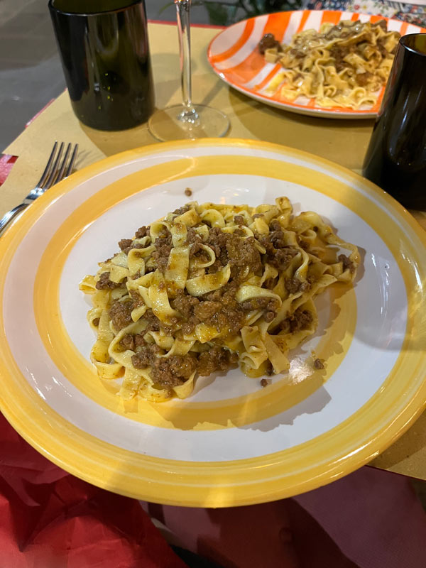 A plate of pasta with meat sitting on a table