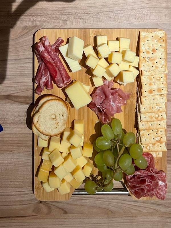 A board with cheese and grapes