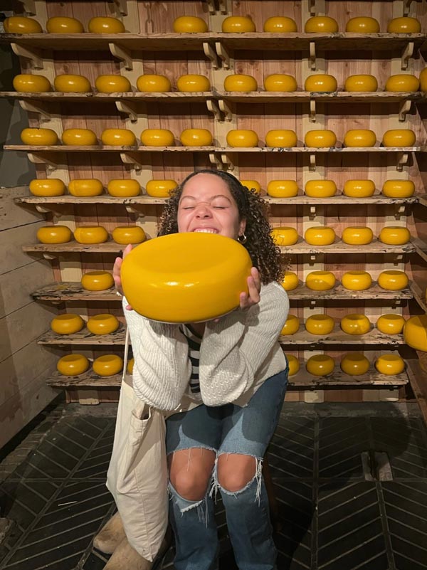 A person holding a wheel of cheese