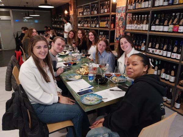 Group of study abroad students sitting around table for wine tasting