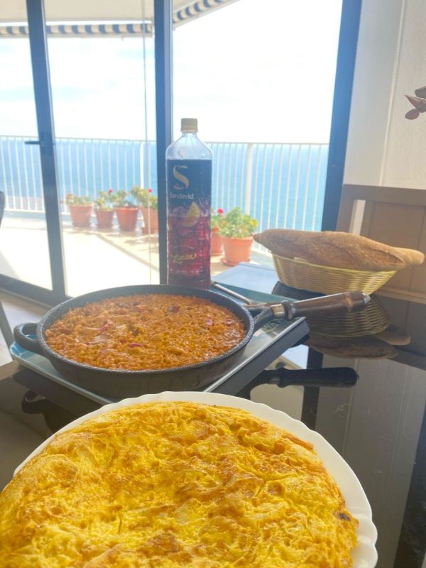 Pan of Paella and  tortilla de patatas and a bottle of  tinto de verano