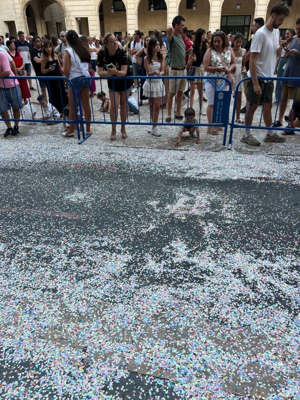 Street covered in confetti and civilians waiting