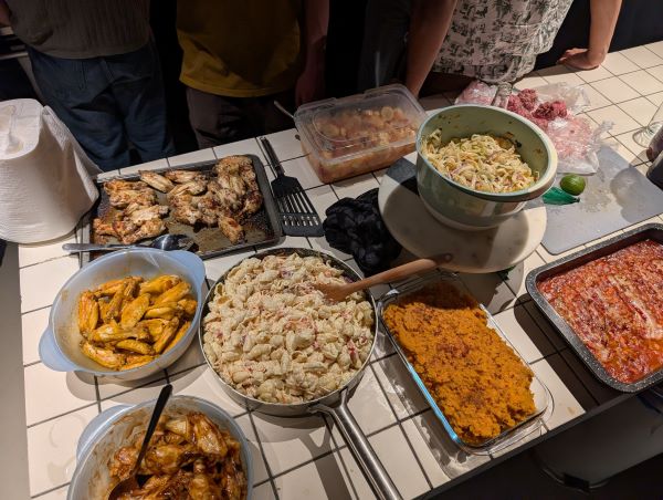 A table full of ready-to-be-served food dishes including meat and pasta dishes