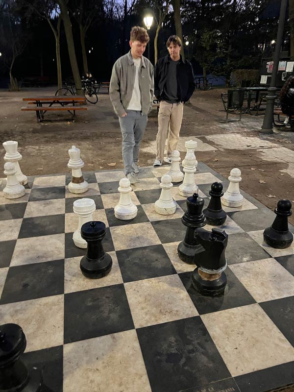 Two study abroad students standing next to a chessboard