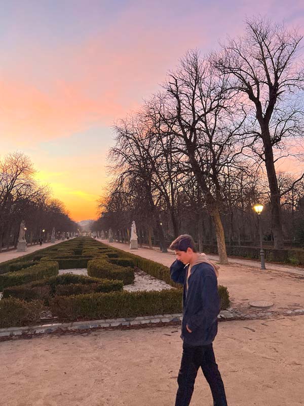 A study abroad student standing in a park at sunset