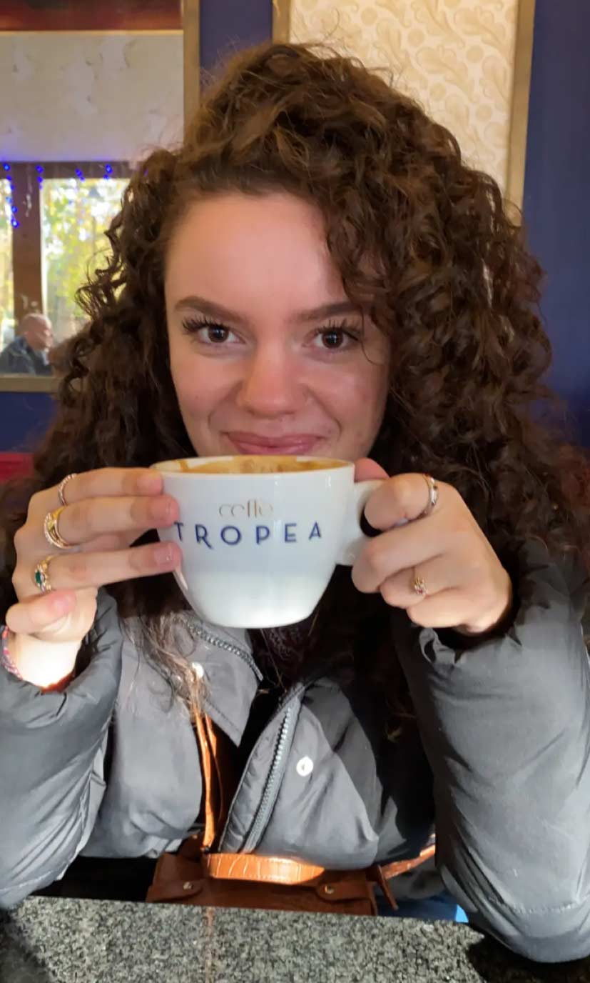 Andrea Arias holding a coffee cup from Cafe Tropea