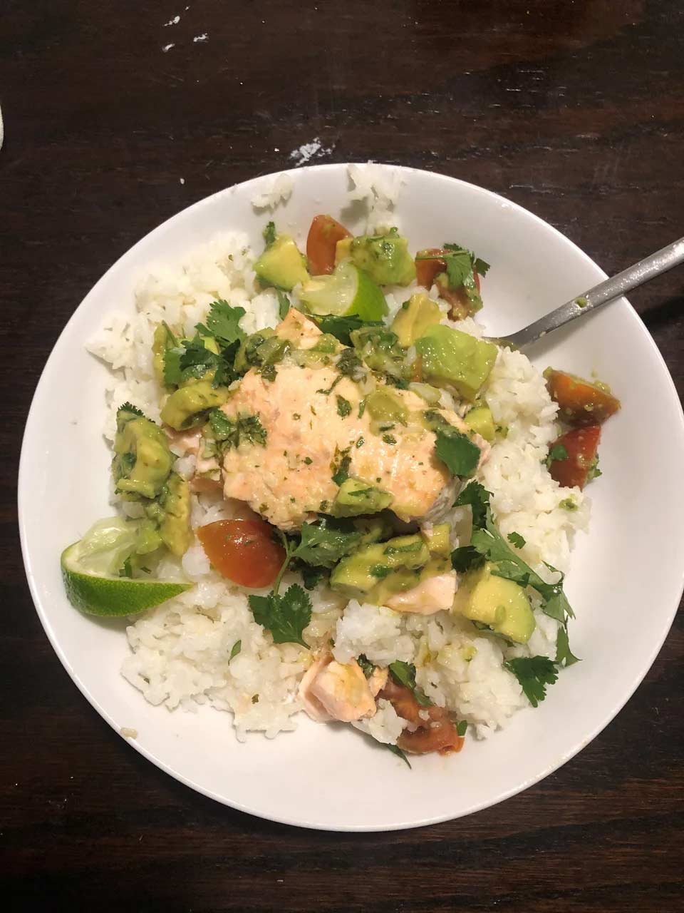 Chicken and rice dish topped with avocado and tomato