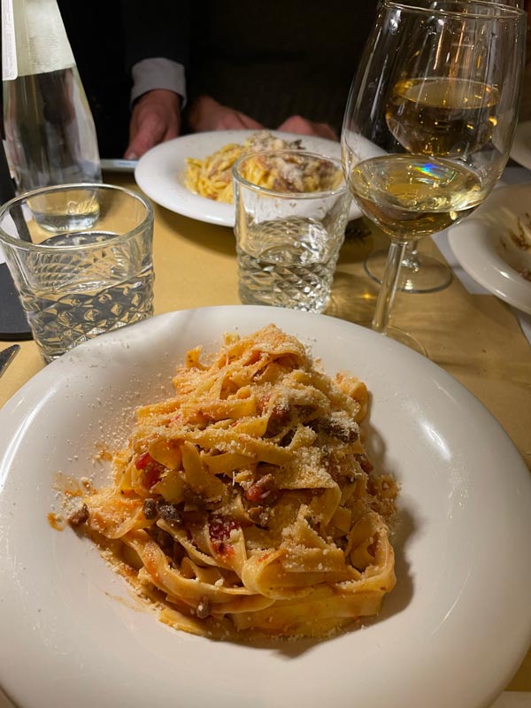 A plate of pasta and glasses of wine