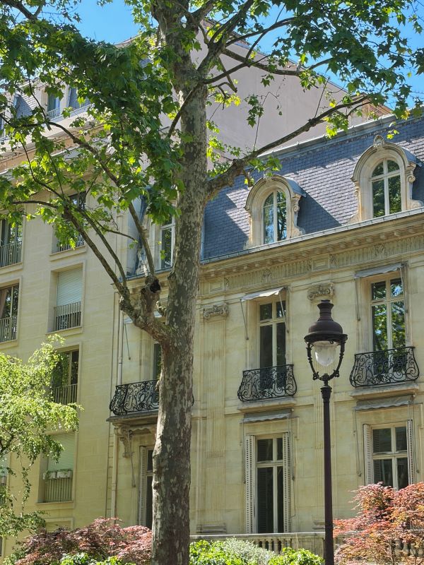 The exterior of an ornately decorated building with trees and bushes in front of it