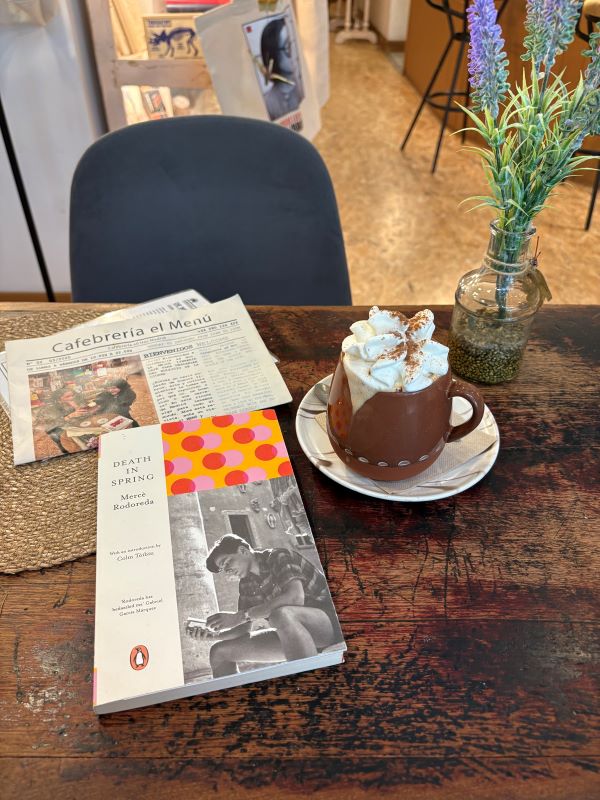 A wooden cafe table featuring a book titled