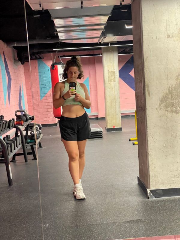 Study abroad student posing for mirror selfie at gym