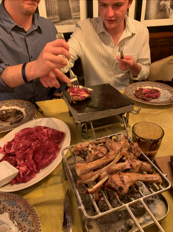 Plate of raw steak next to hot griddle