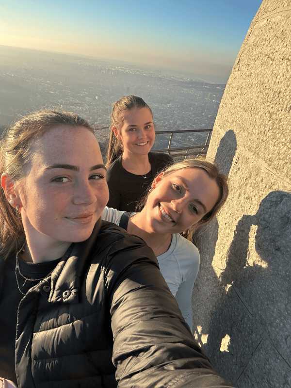 Selfie of three study abroad students walking up the Temple Expiatori del Sagrat Cor 