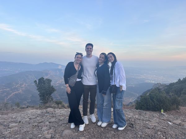 Four study abroad friends posing for photo on mountain