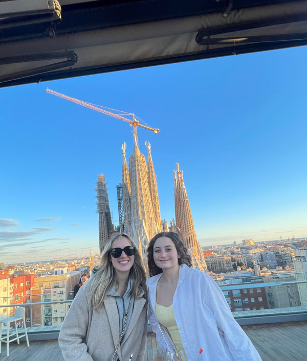 Two study abroad students posing for a picture in front of a tall building
