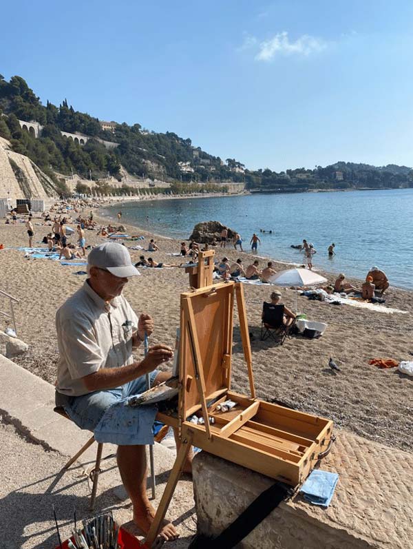 A person painting on a beach