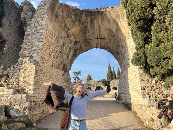 Study abroad student posing for photo in front of ancient arena