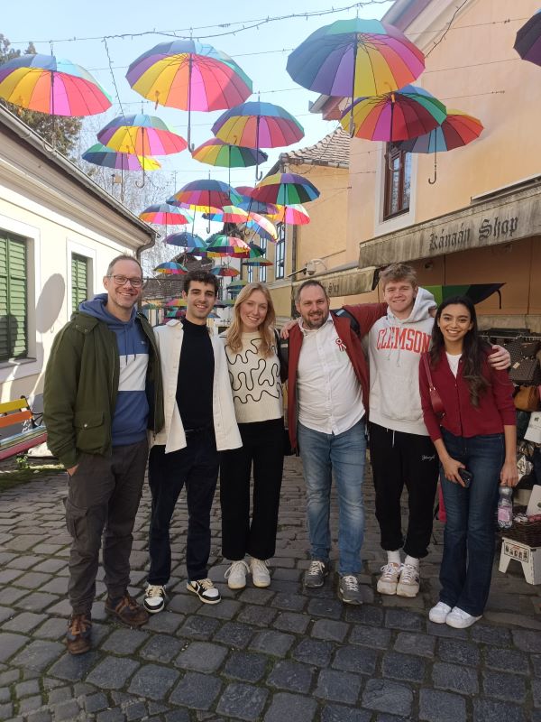 Four study abroad students with their mentors posing for picture