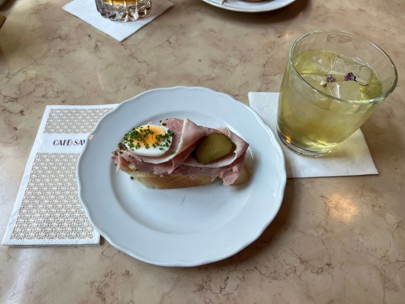 Plated bread with meat and egg on top