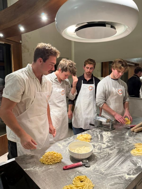 Four study abroad students learning how to make pasta from scratch