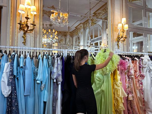 a person examining a dress on a clothing rack