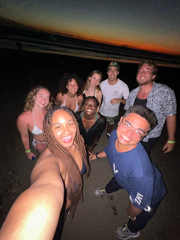 A group of study abroad students posing for a photo on a beach