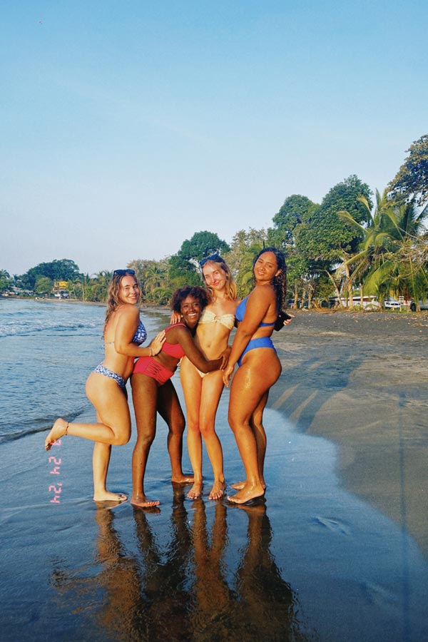 A group of study abroad students in swimsuits on a beach
