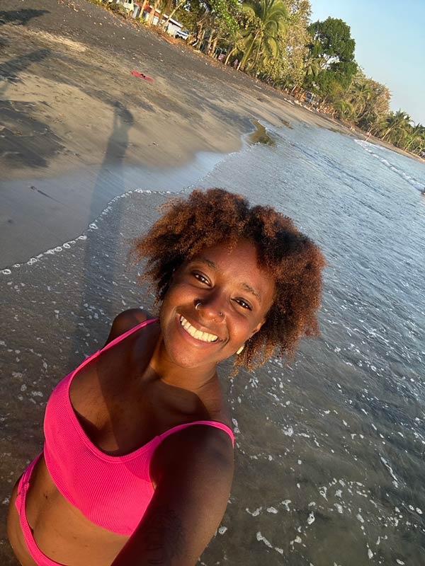 A study abroad student taking a selfie on a beach