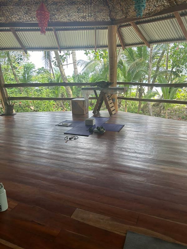A wooden floor with a wooden structure and a wooden table and yoga mats