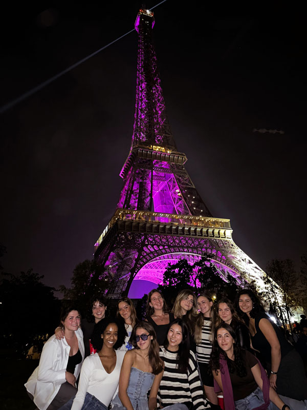 a group of people underneath the Eiffel Tower at night in Paris