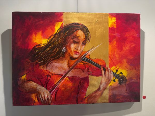 A painting on a wall featuring a figure with long brown hair and wearing a red dress playing the violin