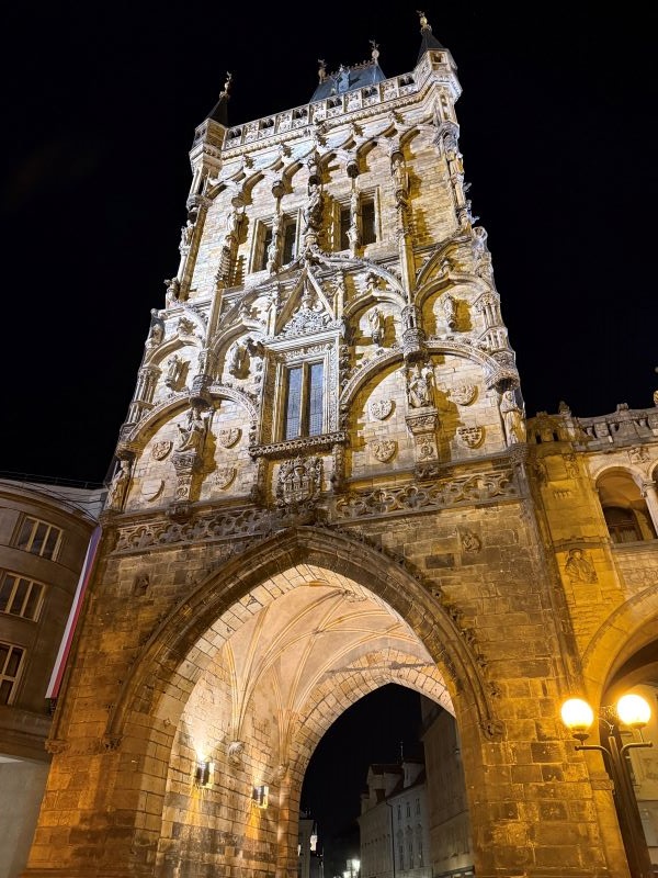 A large intricately-carved tower as seen from below and lit up at night