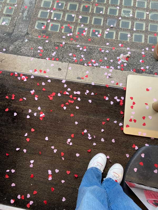 A rug on a floor covered in colorful confetti hearts